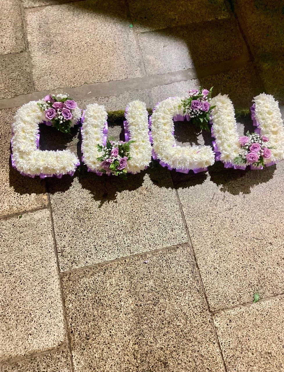 Fresh flower CUCU letter funeral wreath created for memorial services and funeral tributes in Nairobi.