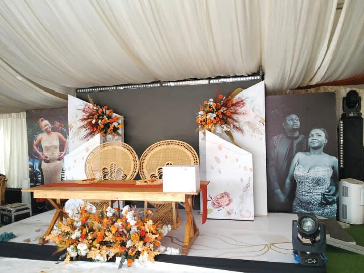 Elegant wedding stage with floral arrangements and seating for ceremony.